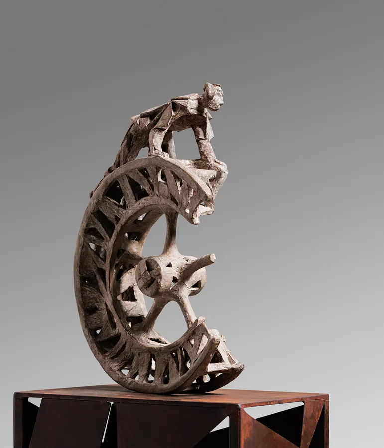 Gebeugte Figur auf Speichenrad — Cortenstahl