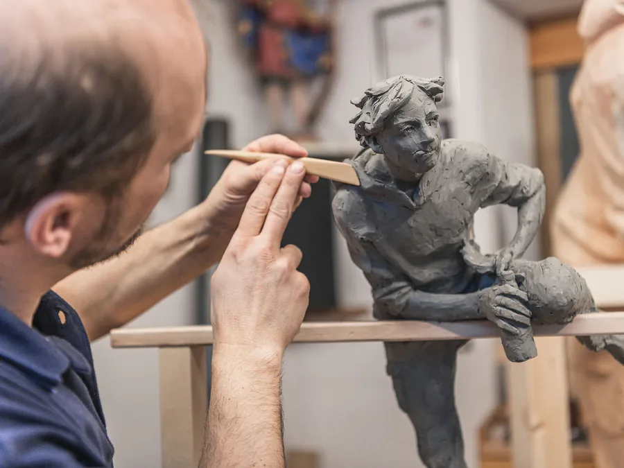 Scultore modella una figura in creta — Legno