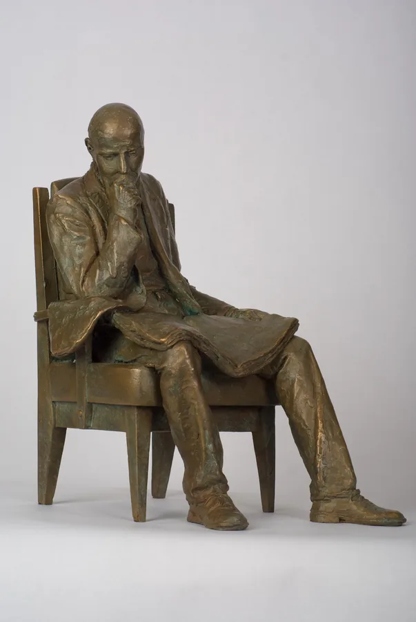 Sitzender Mann mit Zeitung — Bronze
