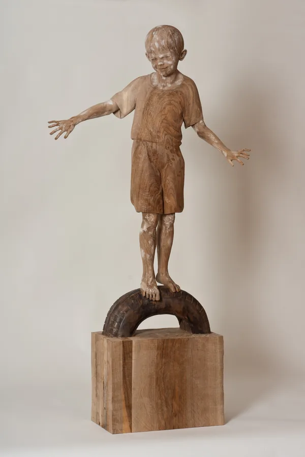 Junge auf dem Autoreifen — Holz